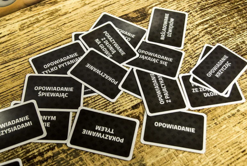 na-drewnianym-stole-czarne-karty-z-trybami-rozgrywki-z-gry-czółko.png